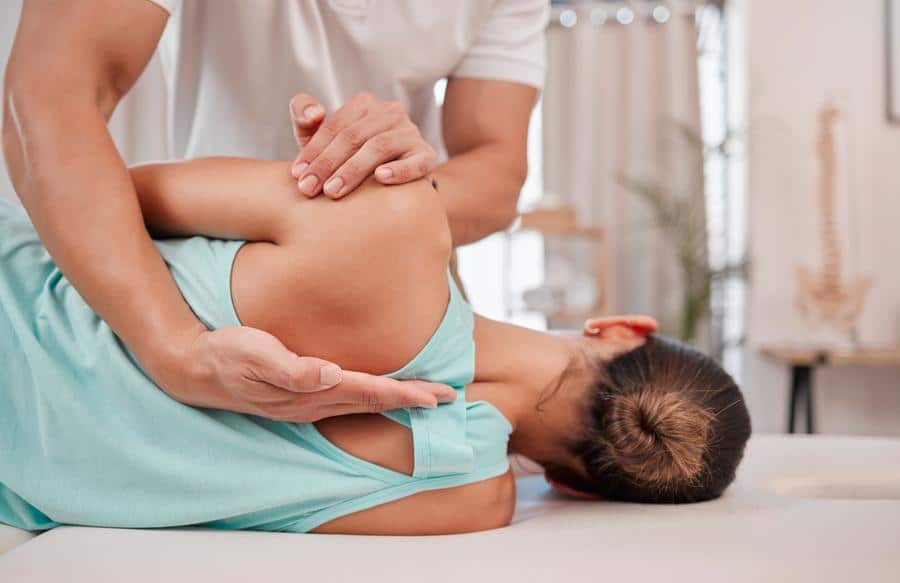 Back-pain-chiropractic-adjustment Chiropractor adjusting back of female patient