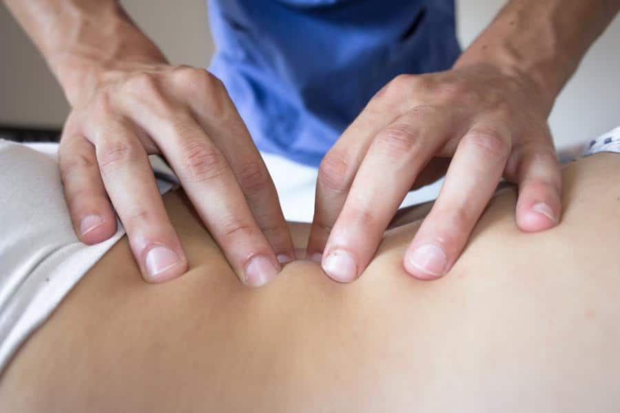 chiropractor massaging patient's back