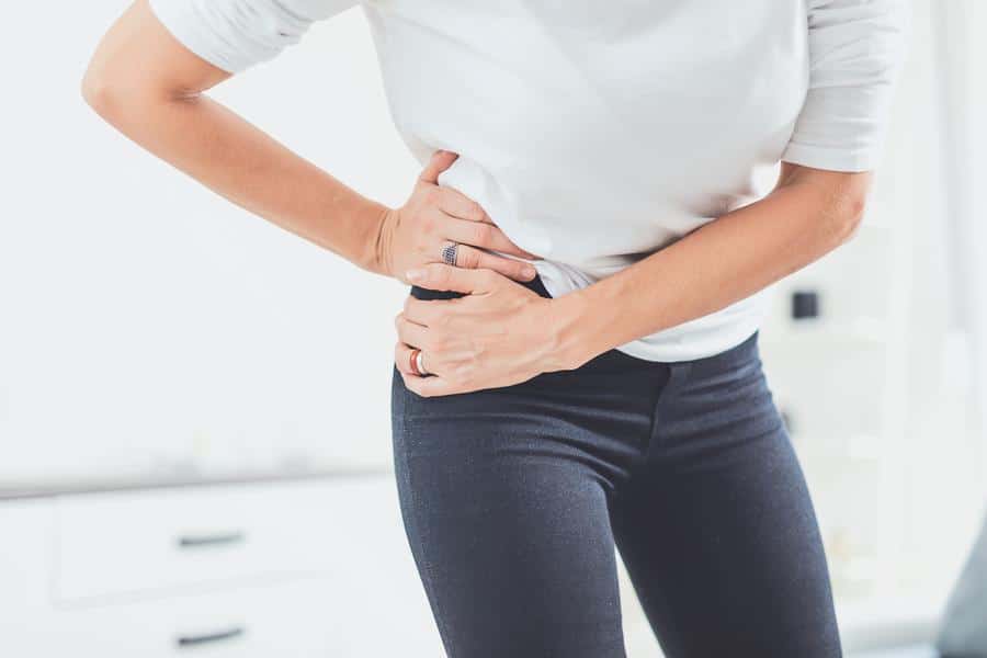 Woman-grabbing-hip-pain Woman holding hip in pain